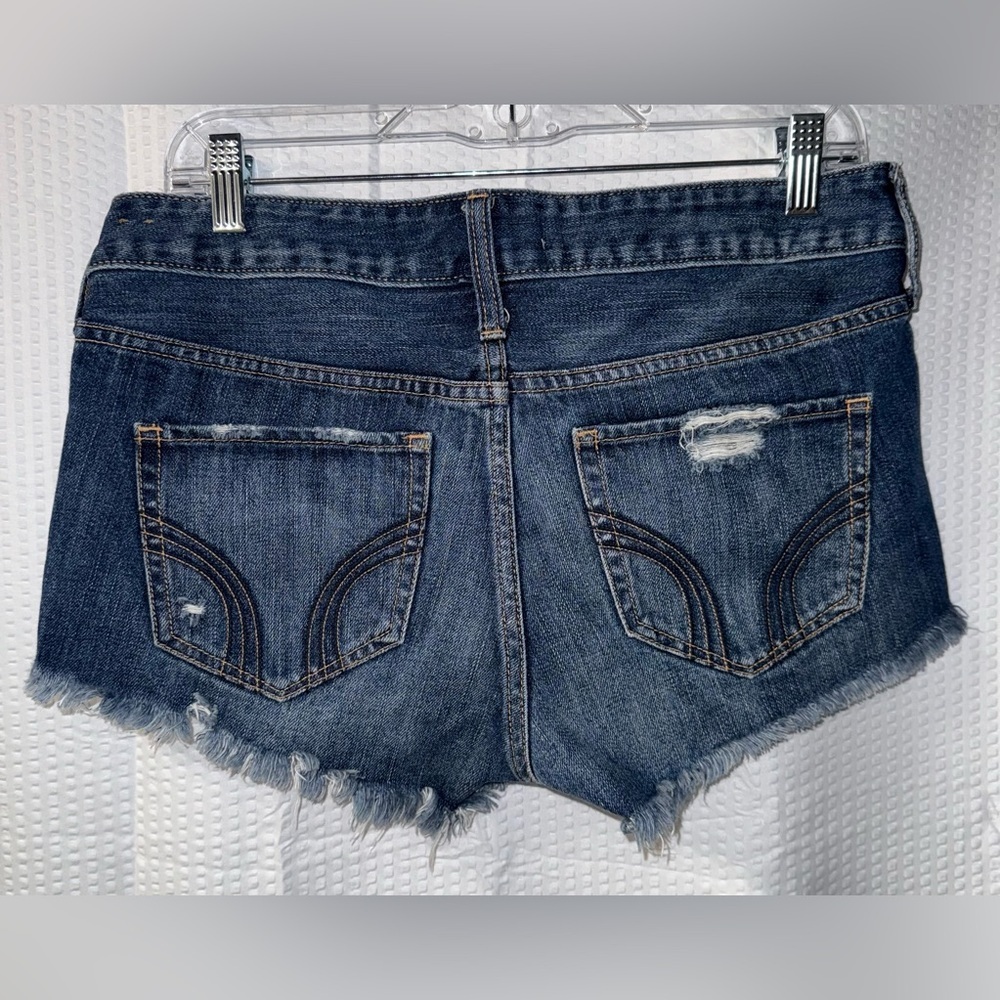 Hollister dark wash distressed denim shorts with a raw hem size 27